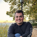 Person sitting outdoors with trees and sunset in the background