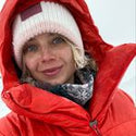 Woman in red winter jacket with white stocking cap.