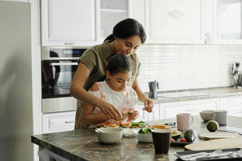 Woman and child preparing food together in a kitchen